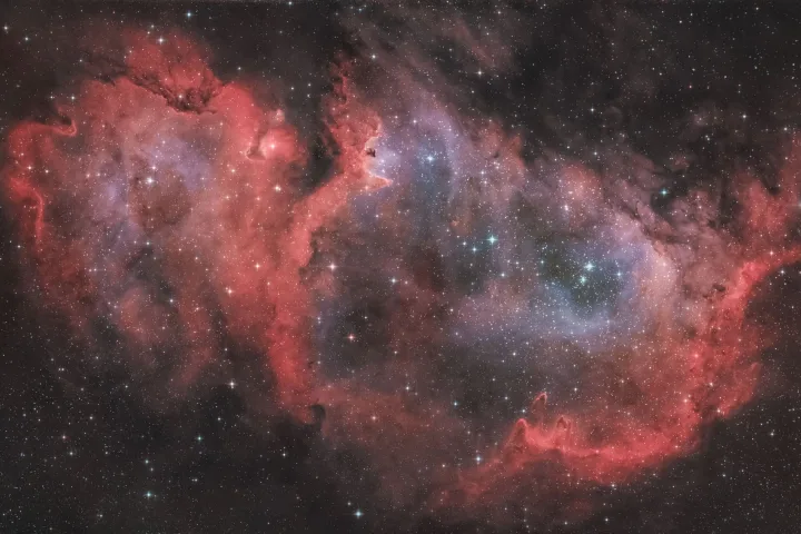 Nebulosa planetaria con un nucleo bianco brillante circondato da strati di gas colorati in blu e viola, fotografata dallo spazio.
