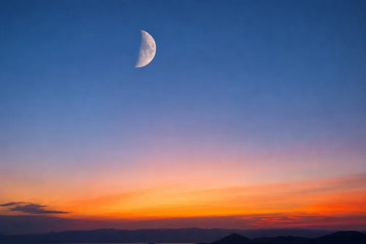 Luna in fase crescente nel cielo al tramonto, fotografico realistico