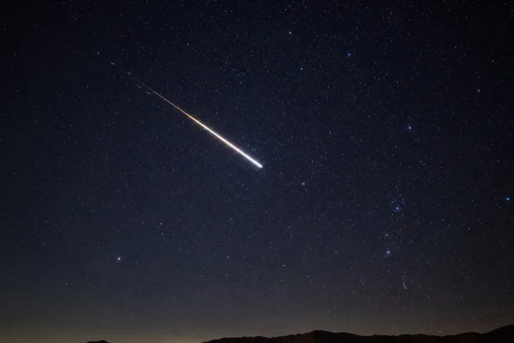 Scia luminosa di una meteora nel cielo stellato notturno