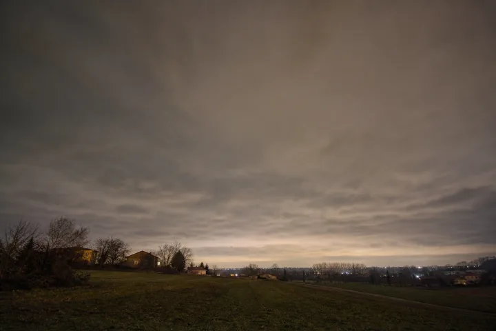 Notte nuvolosa sopra un paesaggio, con cielo coperto che trattiene parte del calore terrestre