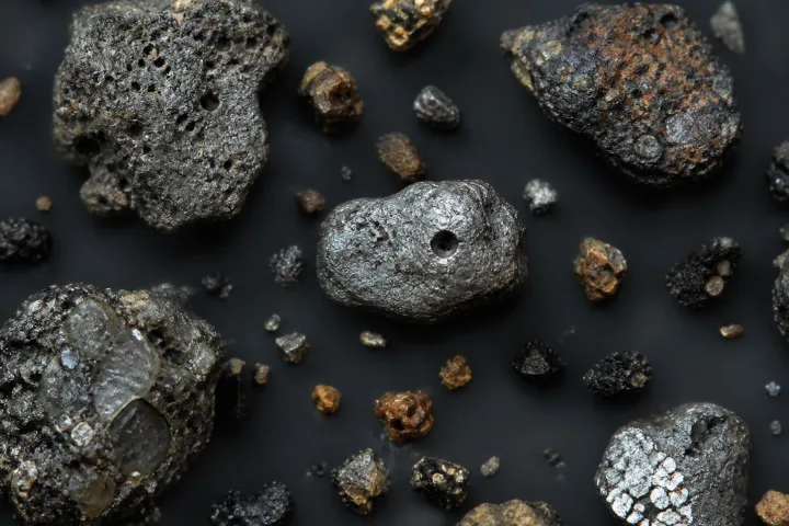 Micrometeoriti al microscopio, granelli di polvere cosmica caduti sulla Terra, immagine scientifica